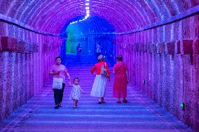 Citizens and tourists play in a converted bomb shelter in Chongqing, China, August 26, 2023. The shelter is illuminated by light
