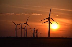 Windmills Turn As The Sun Sets At Meadow Lake Wind Farm