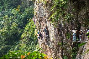 Tourists Experience The Thrilling Rock Climbing on a Cliff in Ningbo