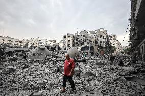 A Palestinians  man walks infront of the rubble of destroyed buildings and mosque after an Israeli air stike in Gaza City, on Oc