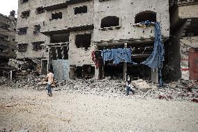 Palestinians walks infront of the rubble of destroyed buildings after an Israeli air stike in Gaza City, on October 9, 2023.