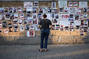 An Israeli woman stands in front of photographs of some of those taken hostage by Hamas