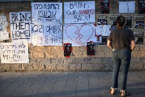 An Israeli woman stands in front of photographs of some of those taken hostage by Hamas