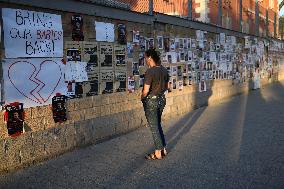 An Israeli woman stands in front of photographs of some of those taken hostage by Hamas