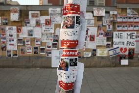 A wall covered with photographs of some of those taken hostage by Hamas