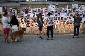 Israelis stand in front of photographs of some of those taken hostage by Hamas during their recent attacks