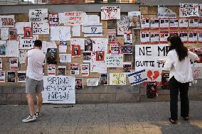 Israelis stand in front of photographs of some of those taken hostage by Hamas during their recent attacks