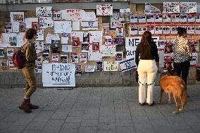 Israelis stand in front of photographs of some of those taken hostage by Hamas during their recent attacks