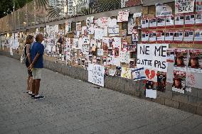 Israelis stand in front of photographs of some of those taken hostage by Hamas during their recent attacks