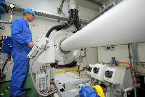 Workers Control Equipment At A Workshop in Yantai