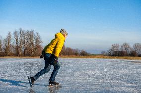 Skating On Natural Ice During Freezing Temperatures, In The Netherlands.
