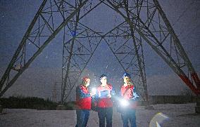 Electric Workers Patrol Power Lines in The Snow