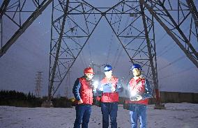 Electric Workers Patrol Power Lines in The Snow