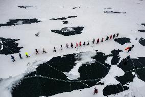 Enthusiasts Hike at Snow-covered Jinlong Lake in Karamay