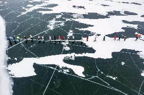 Enthusiasts Hike at Snow-covered Jinlong Lake in Karamay