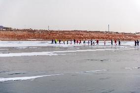 Enthusiasts Hike at Snow-covered Jinlong Lake in Karamay