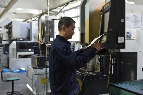 Workers Operate Wire-cut CNC Machine Tools in Fuyang