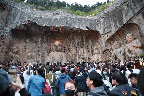 Tourists Visit The Longmen Grottoes in Luoyang