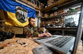 Ukrainian combat drone company soldiers configure FPV drones