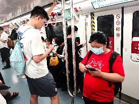 Passengers Play With Phones in Beijing Subway