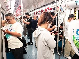 Passengers Play With Phones in Beijing Subway