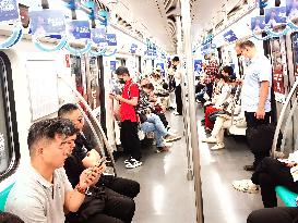 Passengers Play With Phones in Beijing Subway