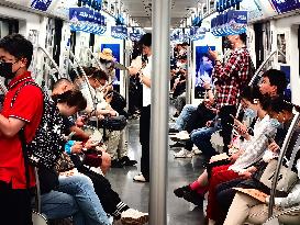 Passengers Play With Phones in Beijing Subway