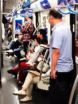 Passengers Play With Phones in Beijing Subway