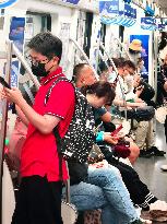 Passengers Play With Phones in Beijing Subway