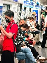 Passengers Play With Phones in Beijing Subway