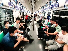 Passengers Play With Phones in Beijing Subway