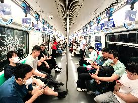 Passengers Play With Phones in Beijing Subway