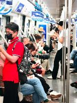 Passengers Play With Phones in Beijing Subway