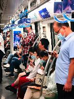 Passengers Play With Phones in Beijing Subway