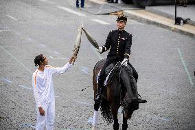 Olympic flame during the annual Bastille Day military parade - Paris