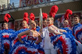 Paris 2024 - The Olympic Flame Stops By The Moulin Rouge