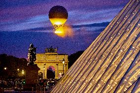 The Cauldron With The Olympic Flame Lit Flies Seen From The Louvre