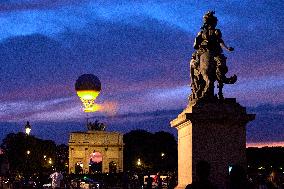 The Cauldron With The Olympic Flame Lit Flies Seen From The Louvre