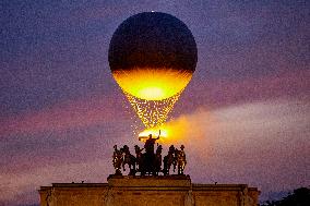 The Cauldron With The Olympic Flame Lit Flies Seen From The Louvre