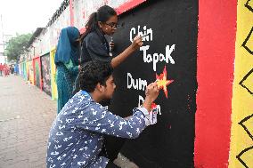 Students Are Painting Graffiti On A Wall Alongside A Road In Dhaka.