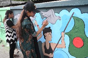 Students Are Painting Graffiti On A Wall Alongside A Road In Dhaka.