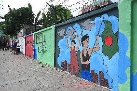 Students Are Painting Graffiti On A Wall Alongside A Road In Dhaka.