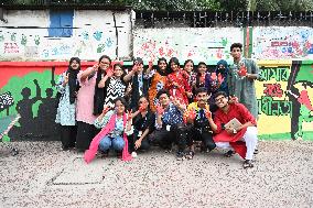 Students Are Painting Graffiti On A Wall Alongside A Road In Dhaka.