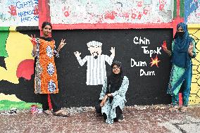 Students Are Painting Graffiti On A Wall Alongside A Road In Dhaka.