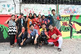 Students Are Painting Graffiti On A Wall Alongside A Road In Dhaka.