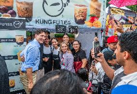 Justin Trudeau greets people as rain falls at Manila festival in Toronto