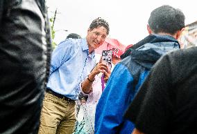 Justin Trudeau greets people as rain falls at Manila festival in Toronto