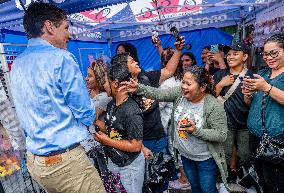 Justin Trudeau greets people as rain falls at Manila festival in Toronto