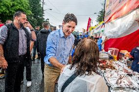 Justin Trudeau greets people as rain falls at Manila festival in Toronto