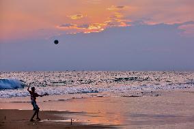 Youth Play A Game Of Football By The Ocean At Sunset In Paruthiyoor